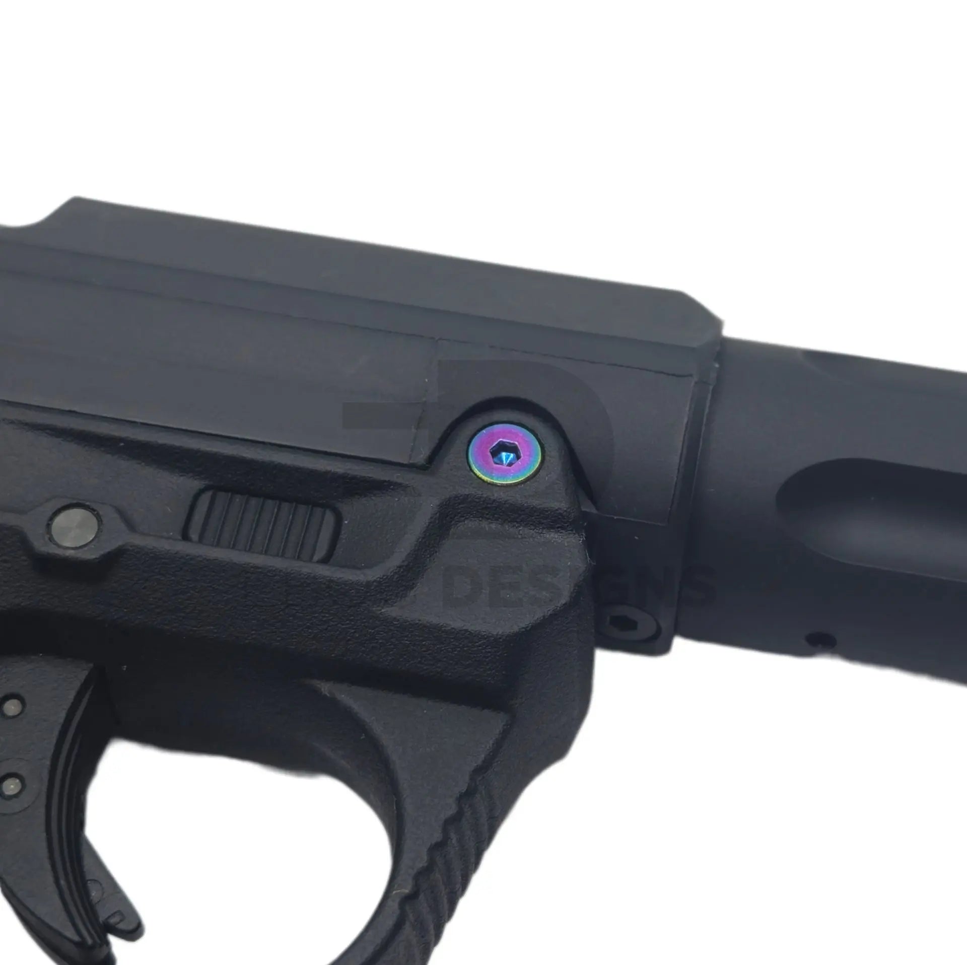 Ebog Designs AAP-01 XL trigger housing side screw fitted to the side of an AAP-01 trigger housing, rainbow