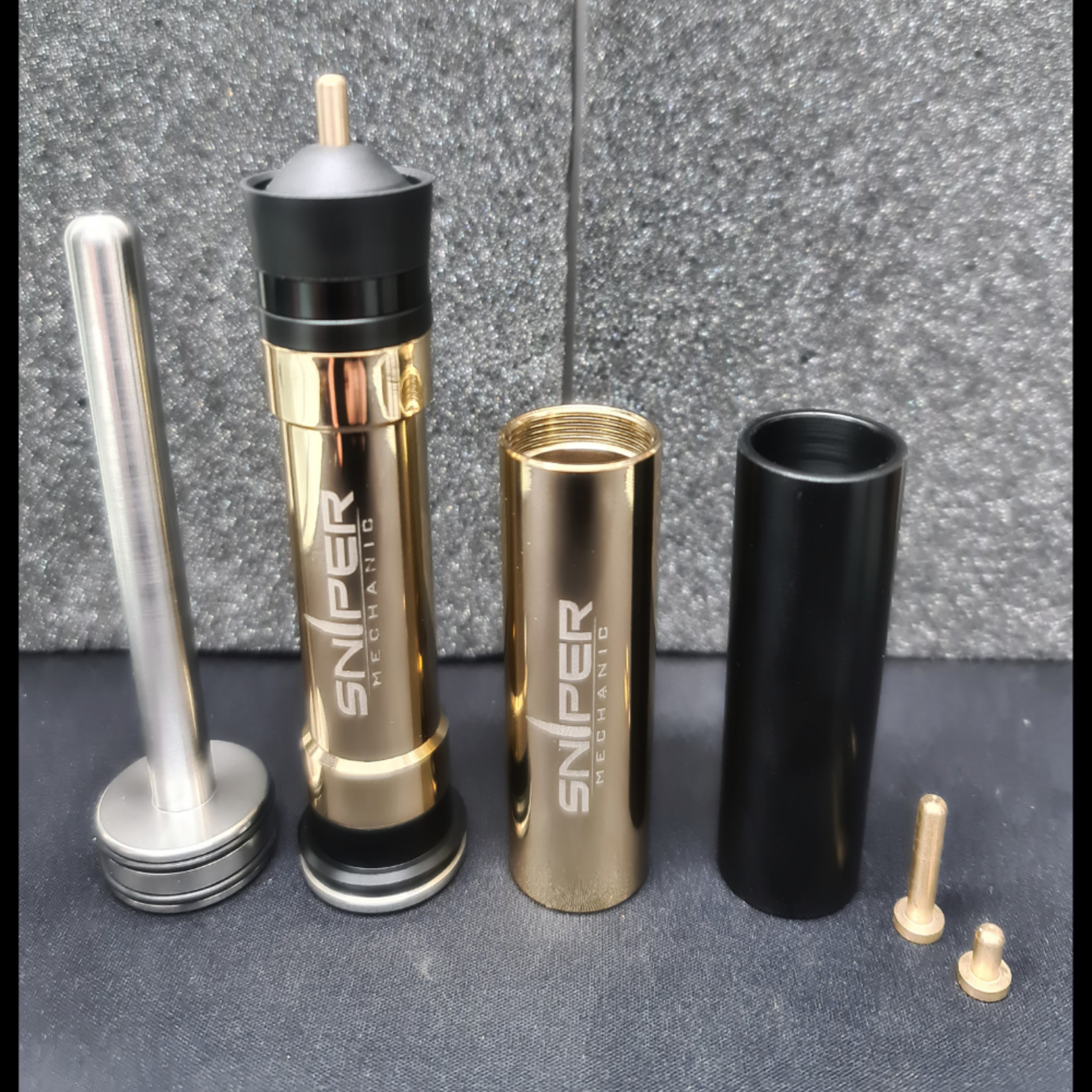 Sniper Mechanics SRS W.A.S.P weight adjustable piston kit laid out: stainless spring guide, gold piston body, weight sleeves and airbrake fittings